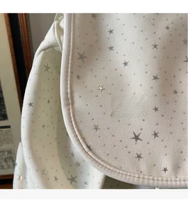 Close-up of minimalist off-white backpack fabric with silver star sequin details