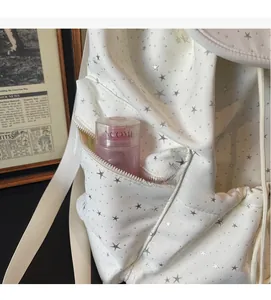 Detail view of the side zipper pocket on a white star pattern backpack with pink bottle