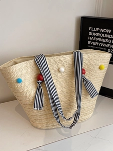 Sac fourre-tout en paille avec pompons colorés et anses rayées bleues pour vacances à la plage