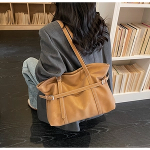 Nahaufnahme einer großen braunen Ledershopper mit weißen Kontrastnähten und Metallschnalle