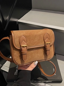 Sac baguette vintage en cuir marron mat avec boucles métalliques et bandoulière