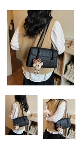 Detail view of black vintage shoulder bag with cute teddy bear charm and polka dot bow