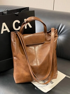 Sac fourre-tout vintage en cuir PU marron ciré sur canapé avec poignées et bandoulière