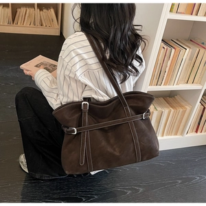 Detailansicht der kaffeebraunen Ledertasche mit weißen Nähten und Silberschnallen