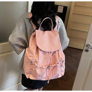 Detail of pink drawstring backpack featuring silver star patterns and flap closure