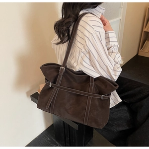 Detail der Vintage-Wildledertasche mit weißen Kontrastnähten und silberner Schnalle