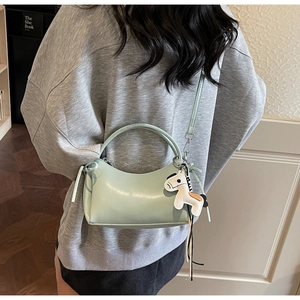 Détail du sac à bandoulière en cuir souple vert menthe avec pendentif petit cheval