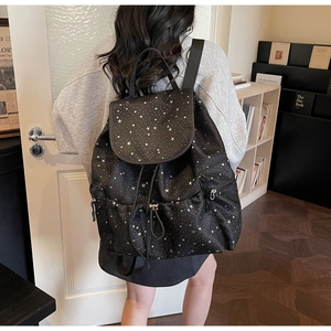 Detail view of stylish black backpack with white star print and drawstring closure design