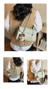 Detail of light green shoulder bag featuring faux leather texture and a cute bear charm
