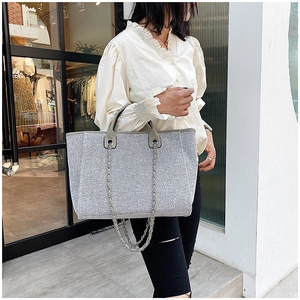 Bolso tote plateado brillante con correa de cadena llevado al hombro para talla