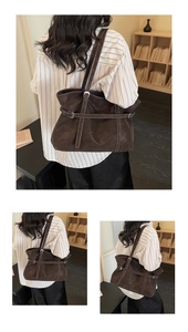Detail of dark brown vintage tote bag featuring decorative belt buckles and white stitching