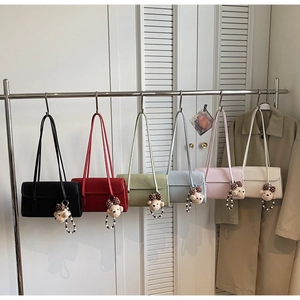 Detailed close-up of colorful shoulder bags with cute bear charms on a display rack