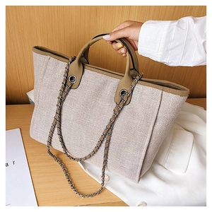 Detalle de textura de bolso tote de lona con cadena y asa de piel sintética