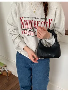 Détail du sac nuage noir minimaliste avec fronces en cuir et logo blanc distinctif