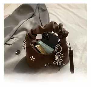Detail view of brown faux suede handbag showing inner capacity for phone and cosmetics