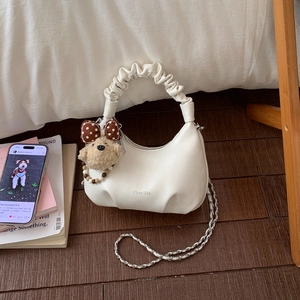 Détail du sac demi-lune blanc plissé avec chaîne dorée et charm ours en peluche
