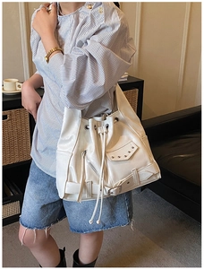 Detail of white vintage tote bag showing motorcycle style rivets and zipper accents