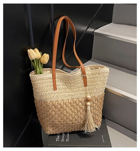 Detail of hollow-out straw weave texture on large tote bag with brown leather handles