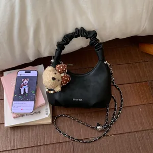 Détail du sac croissant noir avec poignée nuage froncée et breloque ours en peluche