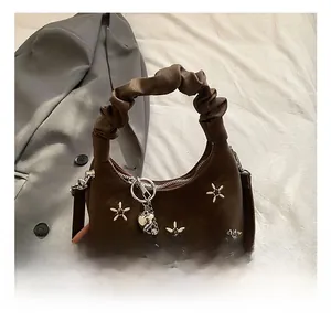 Detail showing dark coffee crescent mini bag with star embroidery and ruffled handle