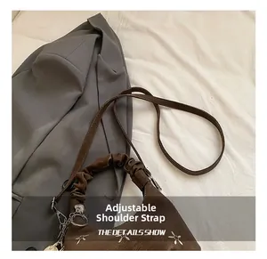Detail of retro brown handbag featuring star metal rivets and adjustable shoulder strap