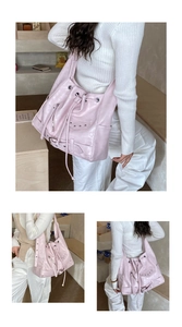 Close-up of soft matte pink leather motorcycle tote bag with rivet and tassel details