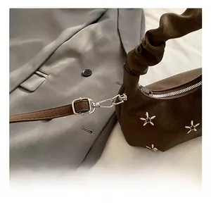 Detail of silver metal hook and strap connector on a brown embroidered cloud bag