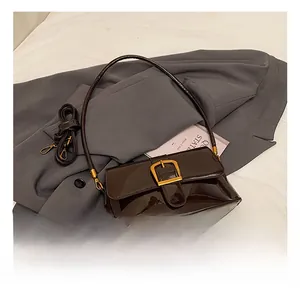 Dettaglio della borsa baguette in vernice marrone scuro con fibbia dorata a ferro di cavallo