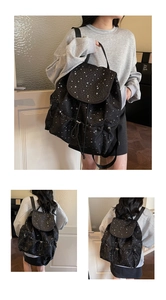 Detail of a lightweight black mini backpack with white stars and drawstring closure
