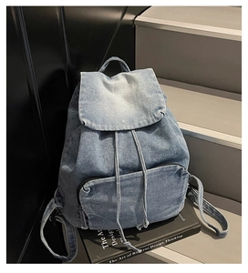 Gros plan sur la texture du sac à dos en jean vintage avec cordon de serrage