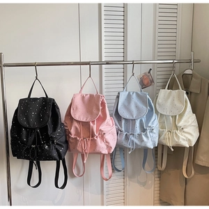 Detailed view of casual backpacks with star prints in black pink blue and beige colors