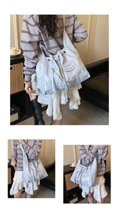 Detailed view of light blue tote bag featuring silver studs and punk motorcycle style