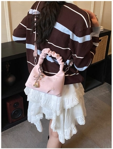 Detailed view of pink shoulder bag with star embroidery and ruffled handle detail