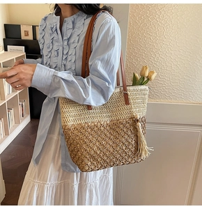 Detail of hollow-out woven tote bag with two-tone gradient design and leather straps