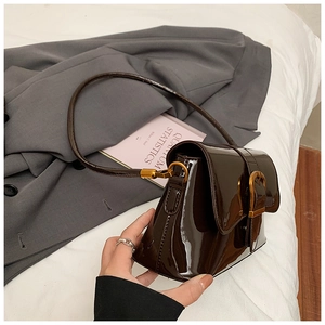 Détail du sac à bandoulière en cuir verni marron brillant avec boucle dorée vintage