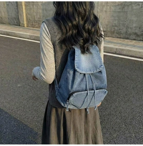 Vue arrière d'un sac à dos vintage en denim avec cordon et poche zippée pratique