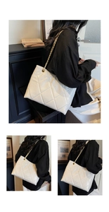 Close-up of cream white quilted tote bag with golden metal chain strap and leather texture