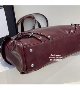 Detail showing the burgundy leather bag bottom with four protective metal rivets