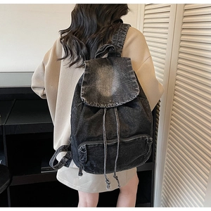 Vue arrière du mannequin portant le sac à dos vintage en denim noir délavé à cordon