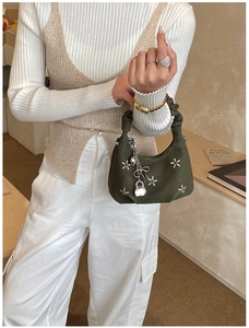 Detail of olive green mini handbag with floral embroidery and ruched cloud handle