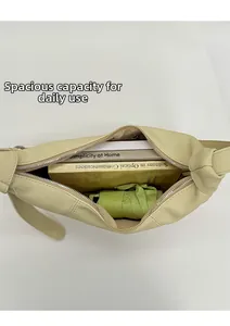 Spacious interior of beige leather tote bag holding two books and a folded umbrella
