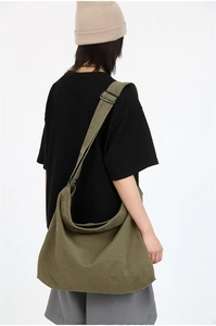 Detail of adjustable strap and olive green canvas crossbody bag on a model
