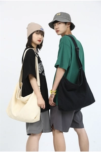 Minimalist oversized canvas crossbody bag shown in beige and black styles by models