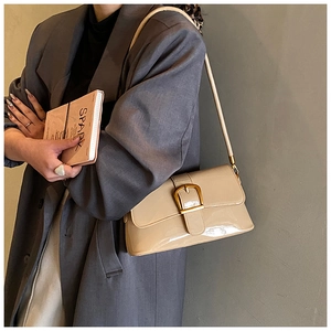 Dettaglio borsa sottobraccio in vernice beige lucida con fibbia quadrata dorata
