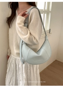 Detail of light blue crescent shoulder bag featuring premium grainy leather and stitched seams