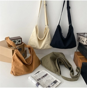 Washed canvas crossbody bags shown in cream, black, yellow, and green colors