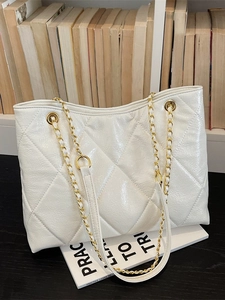 Grand sac cabas blanc matelassé effet verni avec bandoulière chaîne dorée sur bureau
