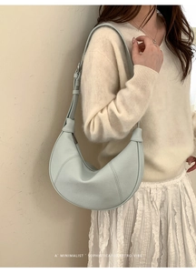 Close-up of mint green half-moon shoulder bag in textured lychee grain leather