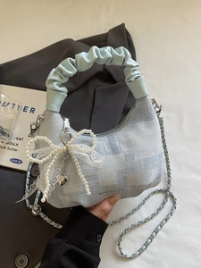 Blue denim half-moon handbag with bow pearl detail and blue ruffled handle