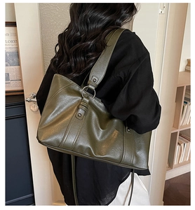 Detail of olive green vintage tote bag with wrinkled leather texture on a female model